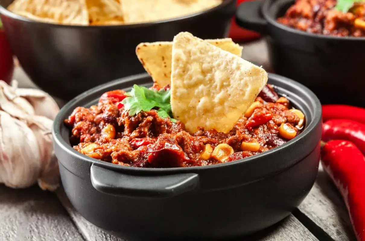 Gorące dania na imprezę: chili con carne z nachos, czosnkiem i papryczkami. Idealne na spotkanie!