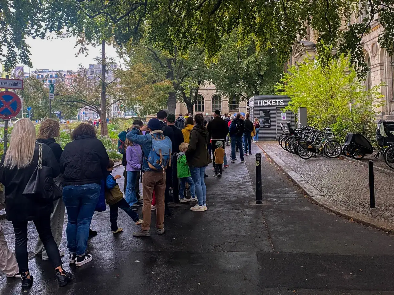 Kolejka do kasy biletowej przy Muzeum Historii Naturalnej w Berlinie. W tle budynek muzeum i drzewa.