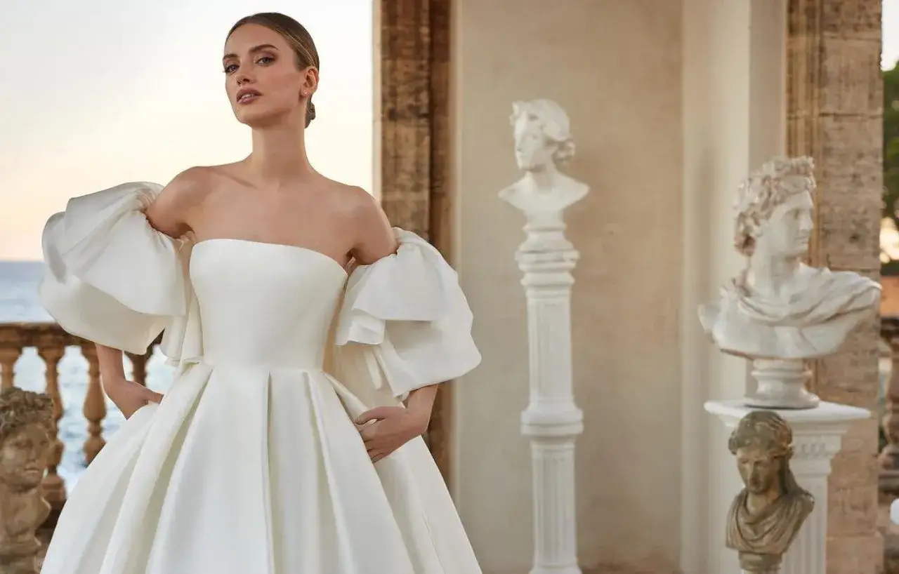 Una sposa in abito bianco con maniche a sbuffo, un'icona di eleganza. Il suo significato &egrave; la promessa di un futuro radioso.