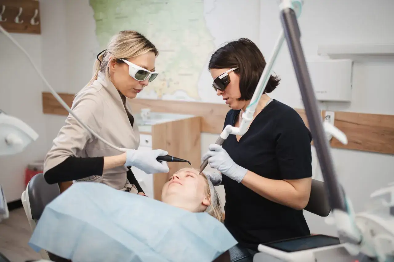 dentysta wykonujący zabieg medycyny estetycznej na twarzy