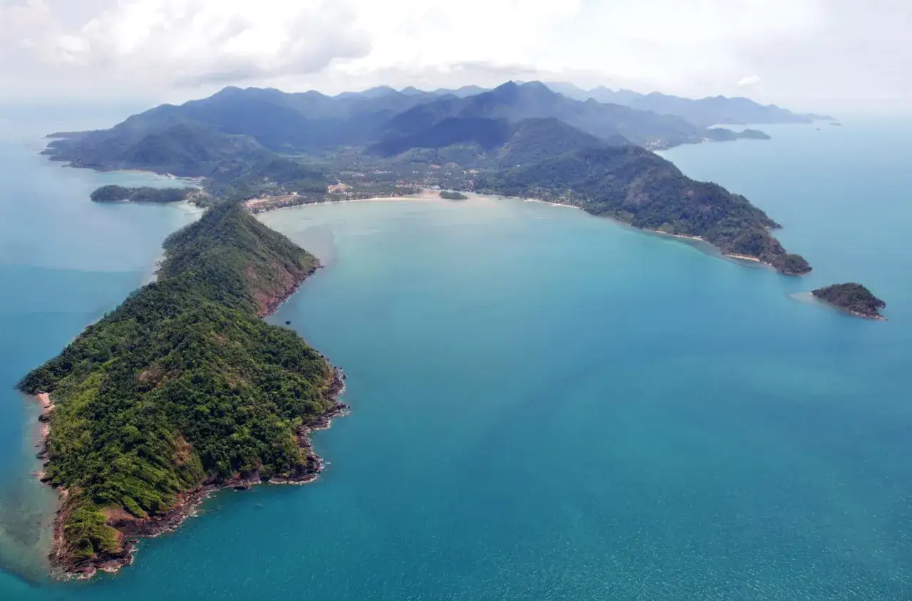 Luftvy över Ko Chang, Thailand. Gröna berg möter turkost hav vid en bukt med stränder och små öar.
