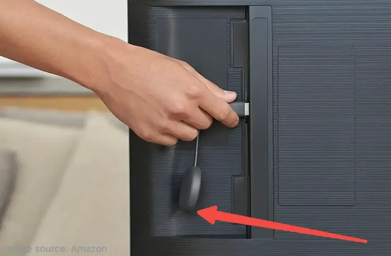 Hand steckt HDMI-Stick in den Fernseher, um den Chromecast zur&uuml;ckzusetzen. Roter Pfeil zeigt auf das Ger&auml;t.