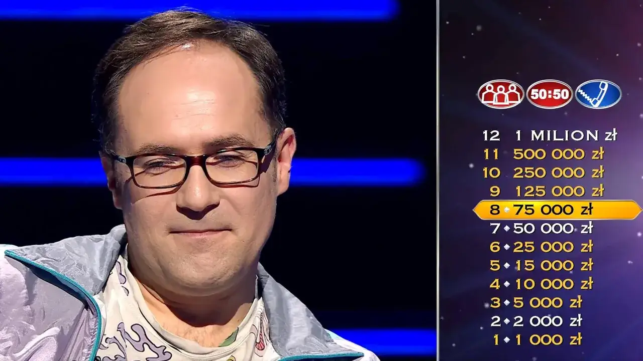 Uśmiechnięty mężczyzna w okularach, obok niego lista nagród w teleturnieju. Co dajemy komuś na drogę milionerzy? 75 000 zł!