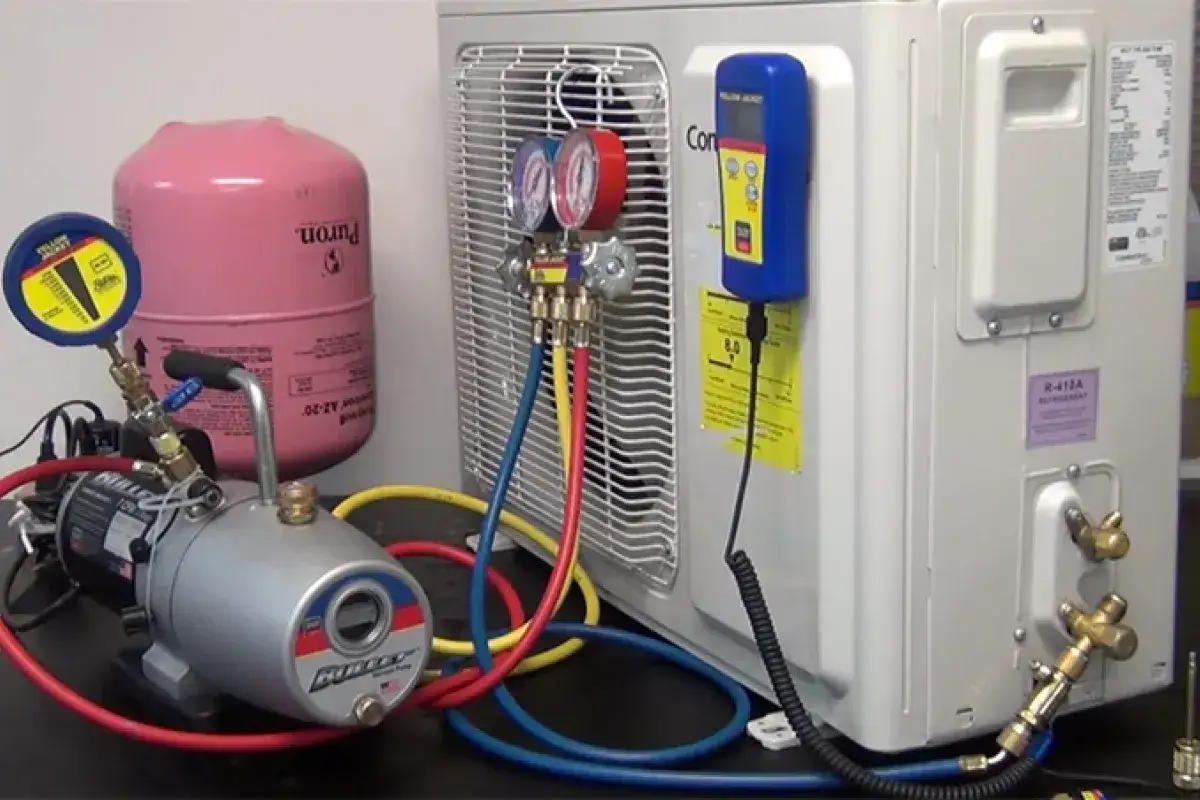 Equipo para crear vac&iacute;o en aire acondicionado: bomba, man&oacute;metros, tanque de refrigerante y unidad exterior.