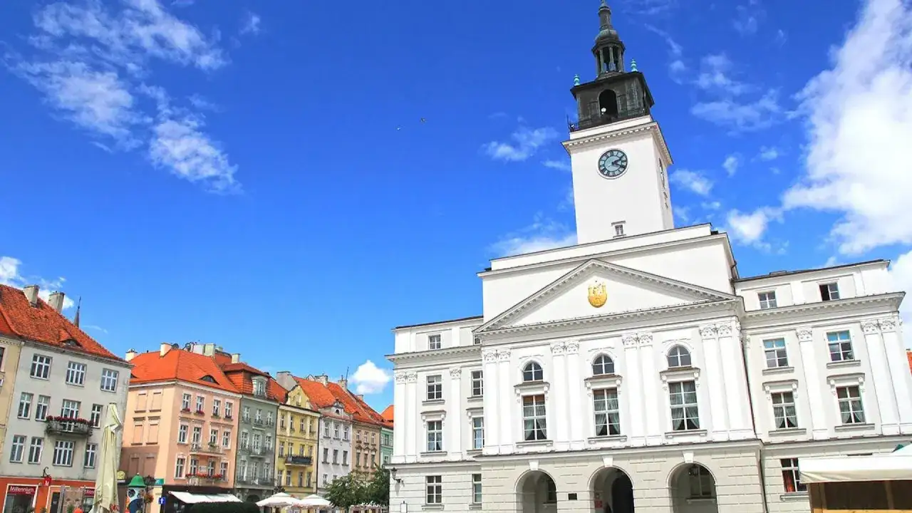 Ratusz w Kaliszu, z charakterystyczną wieżą i zegarem, g&oacute;ruje nad kolorową zabudową rynku. To serce miasta i jedna z jego gł&oacute;wnych atrakcji.
