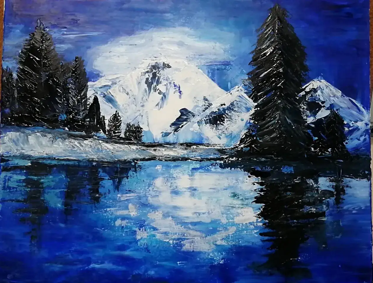 Peinture montagne facile : un paysage hivernal avec des sommets enneig&eacute;s, des sapins sombres et un lac refl&eacute;tant le ciel bleu profond.