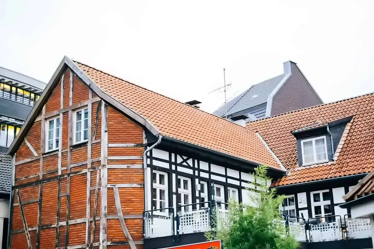 Charakterystyczna konstrukcja mur pruski na fasadzie starej kamienicy z ceglanymi wypełnieniami i drewnianymi belkami.