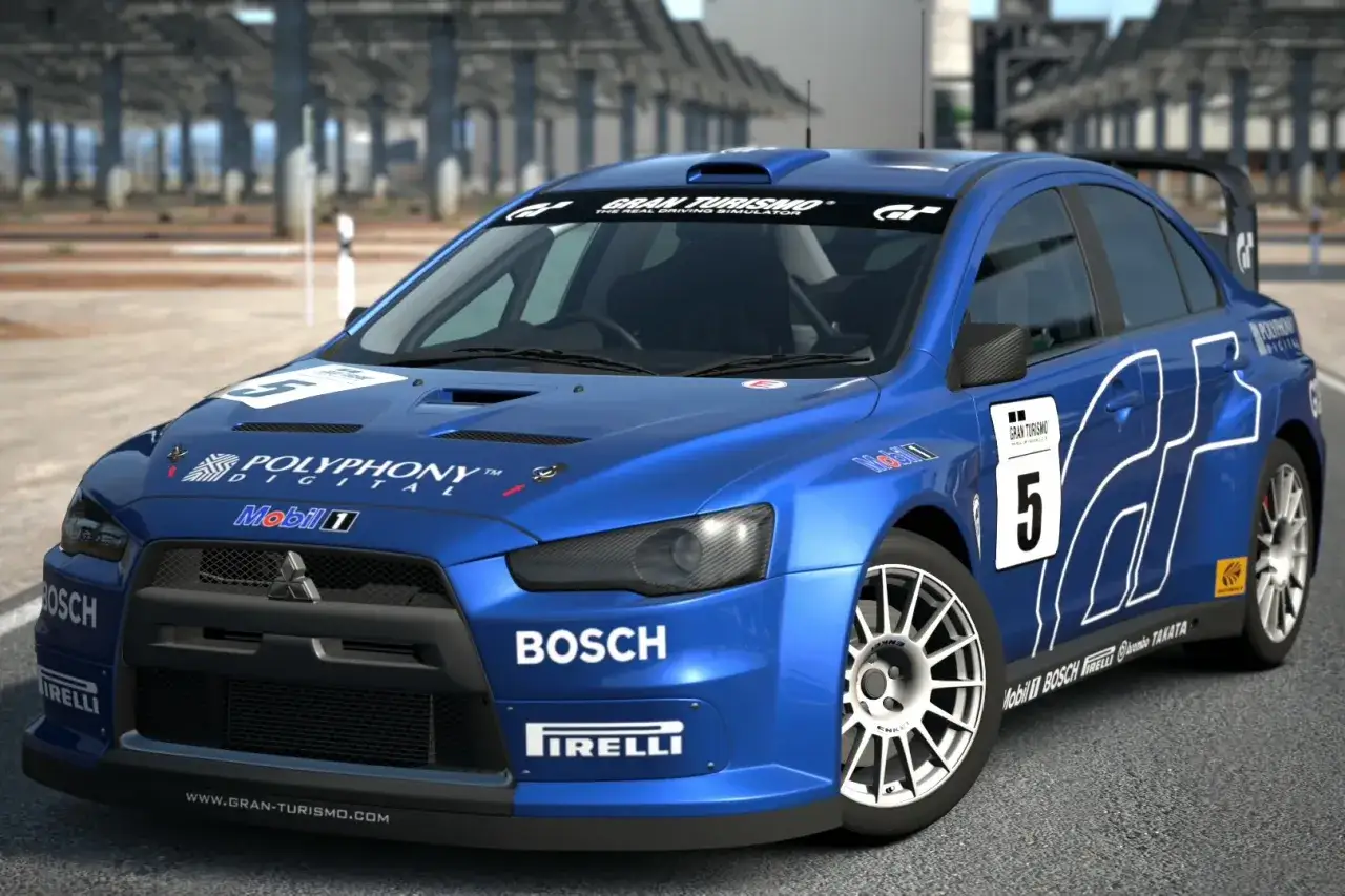 Niebieskie Mitsubishi Lancer Evo 9 z numerem 5 i logotypami sponsorów, gotowe do wyścigu na torze Gran Turismo.