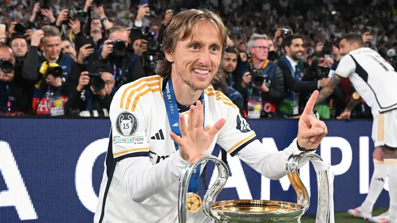 Luka Modrić, el jugador con m&aacute;s Champions, celebra con la copa. Muestra cinco dedos, simbolizando sus victorias.