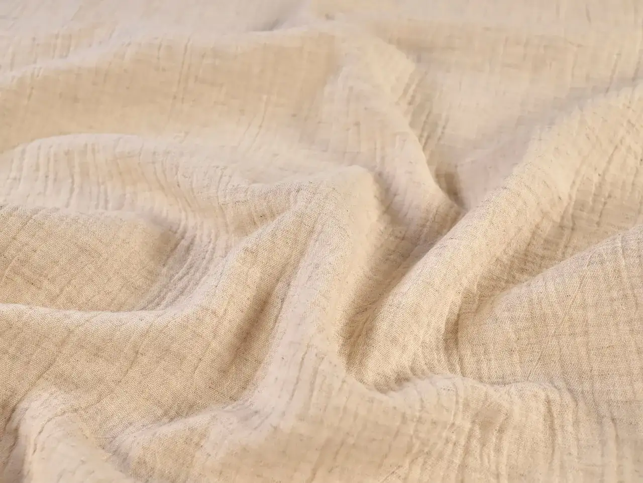Soft, crinkled double gaze de coton in a natural, light beige hue. The fabric drapes beautifully, showing its textured weave.