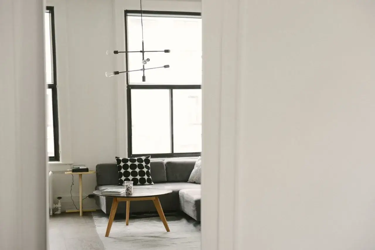 Gemütliches Wohnzimmer mit Sofa, Couchtisch und Fenster. Ein schönes Beispiel, wie man Dinge **verschenken statt wegwerfen** kann, indem man sie neu arrangiert.