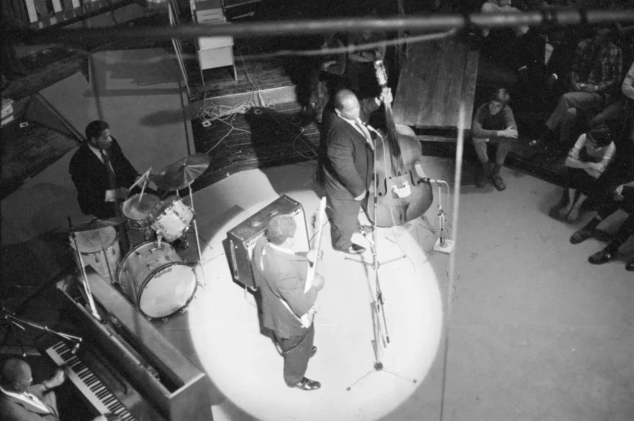 En jazzkväll i Stockholm. En kontrabasist, trummis och pianist spelar blues för en publik.