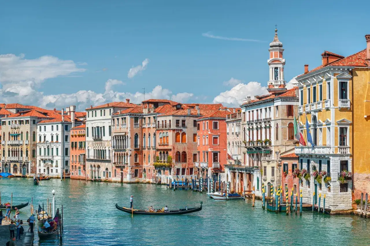 Gondole scivolano sul Canal Grande, tra palazzi colorati e 10 cose da vedere a Venezia.