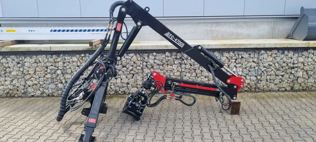 Schwarzer Forstkran FC-4700S mit Greifer und hydraulischer Abstützung, bereit für den Einsatz im Wald.