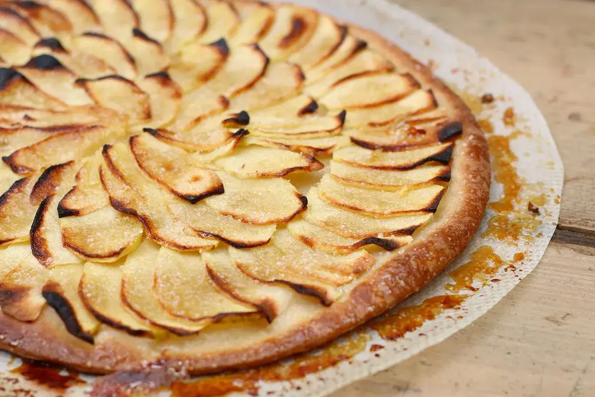 Tarte aux pommes sur pâte feuilletée, les fines tranches de pommes caramélisées et dorées sur un lit croustillant. Un délice !