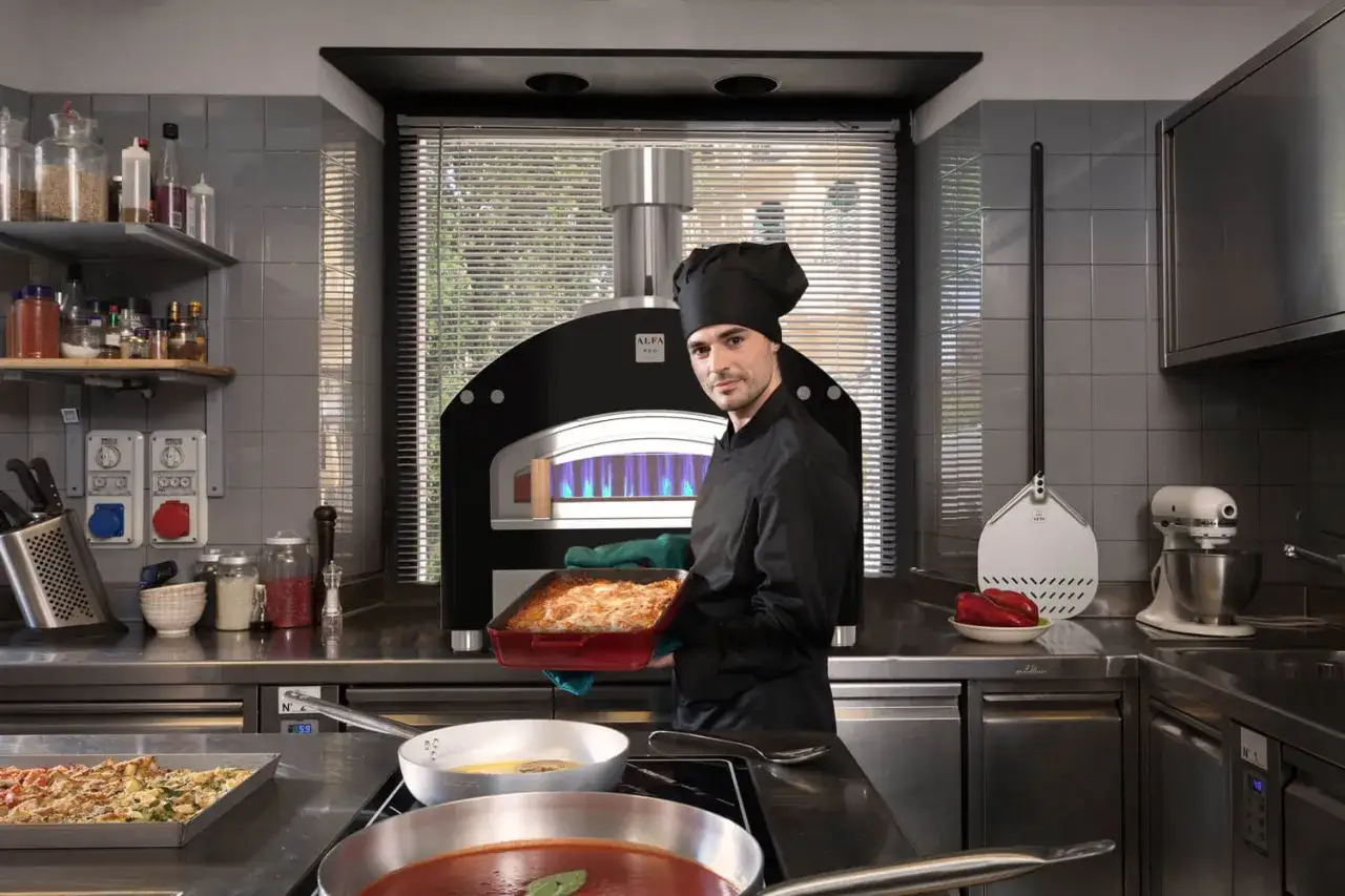 Chef con horno de pizza profesional, listo para mostrar cómo montar una pizzeria. Ingredientes y utensilios a la vista.