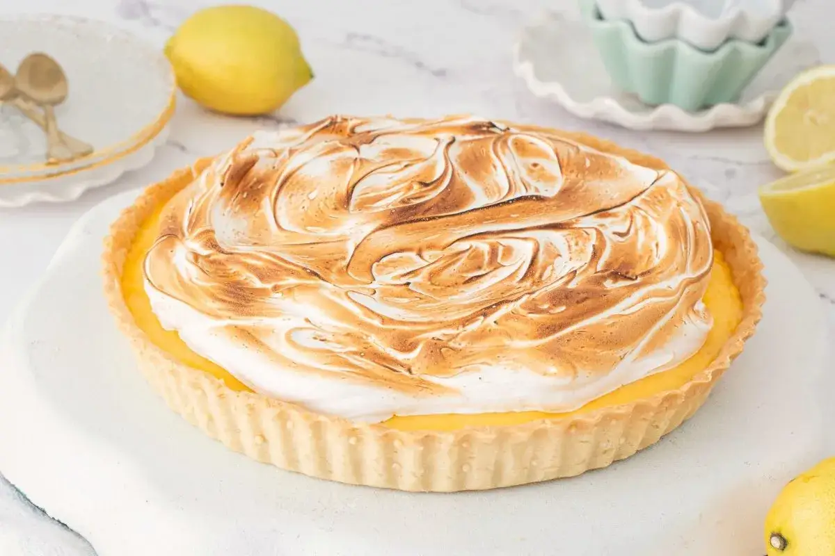 Tarta de limón con merengue dorado y bordes crujientes. Un postre refrescante y delicioso.