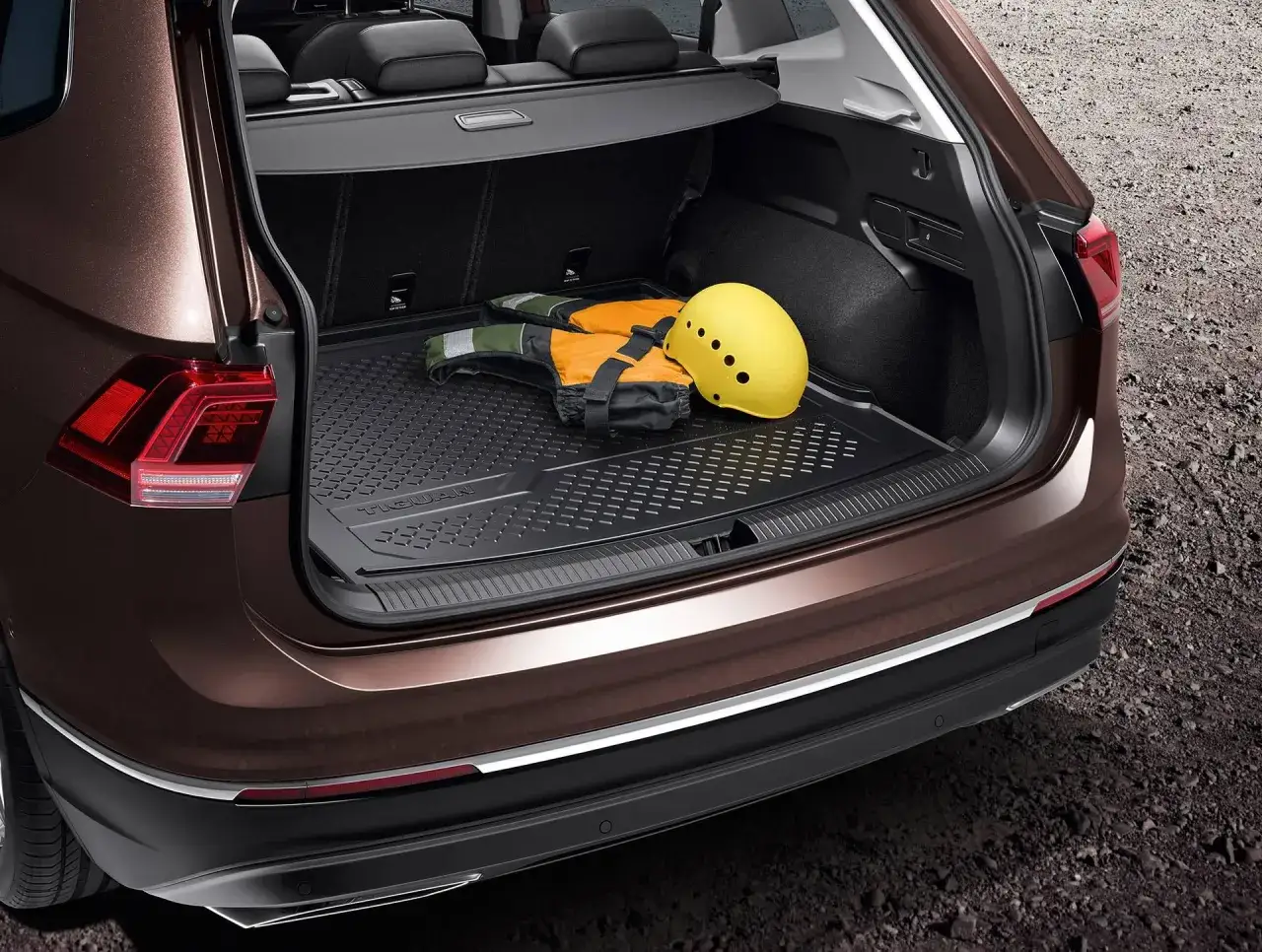 Bagażnik VW Tiguan Allspace gotowy na przygodę: kamizelka ratunkowa i kask czekają na wyjazd.