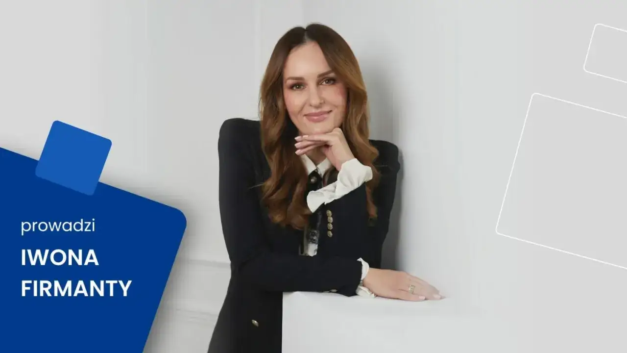 Iwona Firmanty, doświadczony konsultant szkolenia, z uśmiechem opiera się o ścianę.