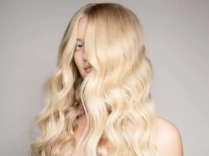 kobieta nakłada toner na włosy blond