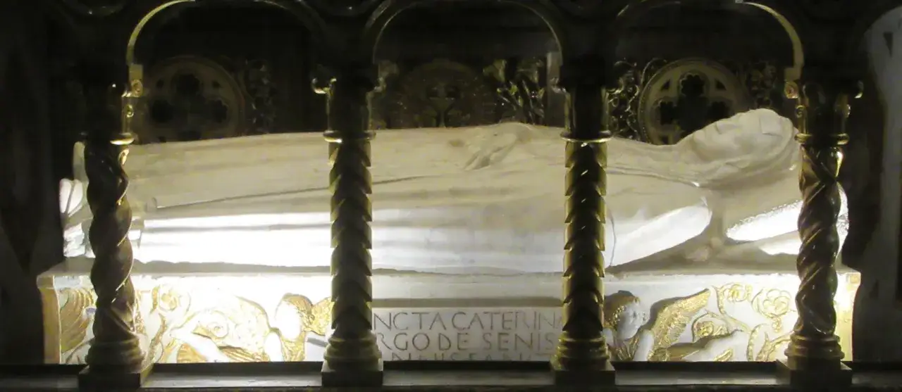 Reliquie der heiligen Katharina von Siena in einem kunstvoll verzierten Sarkophag. Goldene Engel und Inschriften zieren den Sockel.