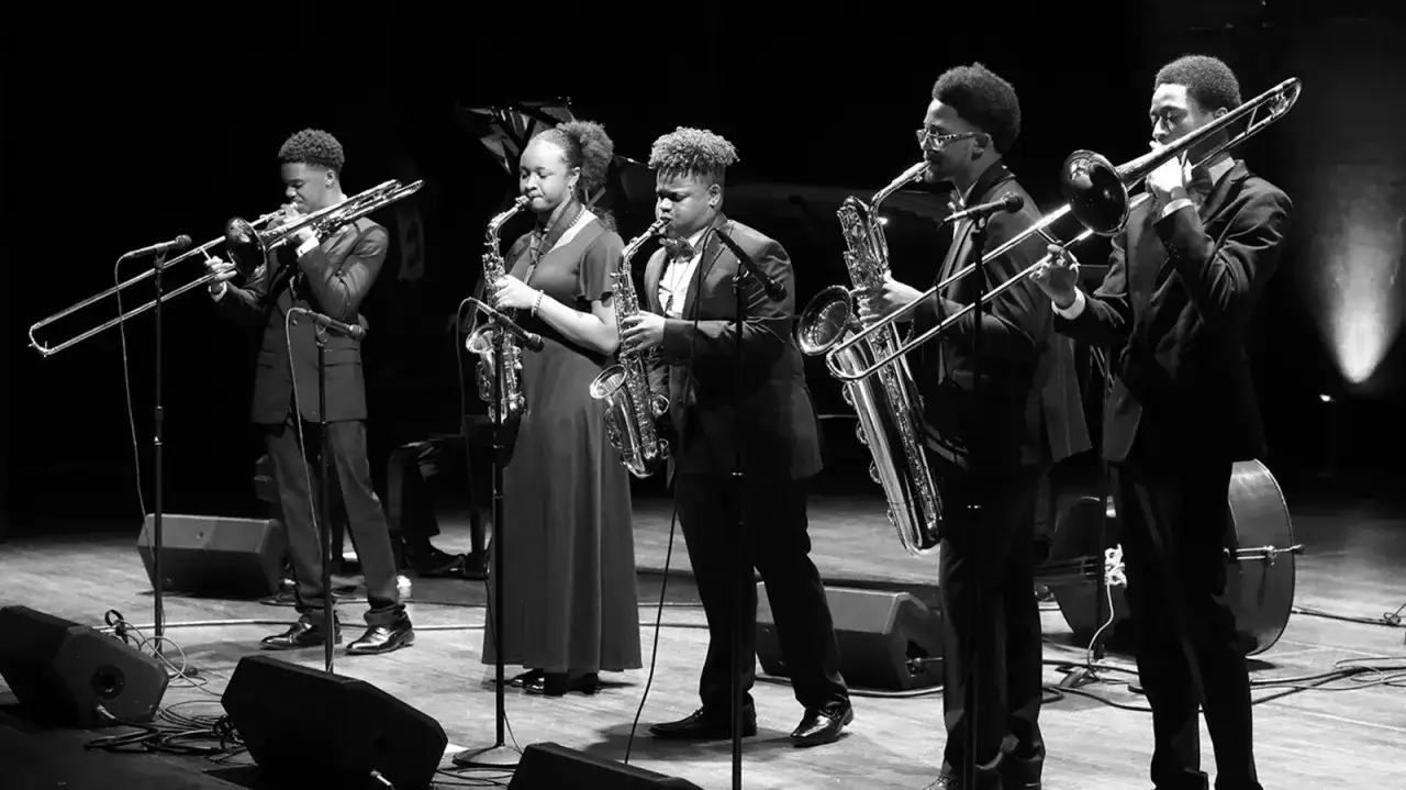 Eine Jazzband spielt auf der Bühne. Die Musiker spielen Saxophone und Posaunen. Das ist, was Jazz ist: Musik, die begeistert.