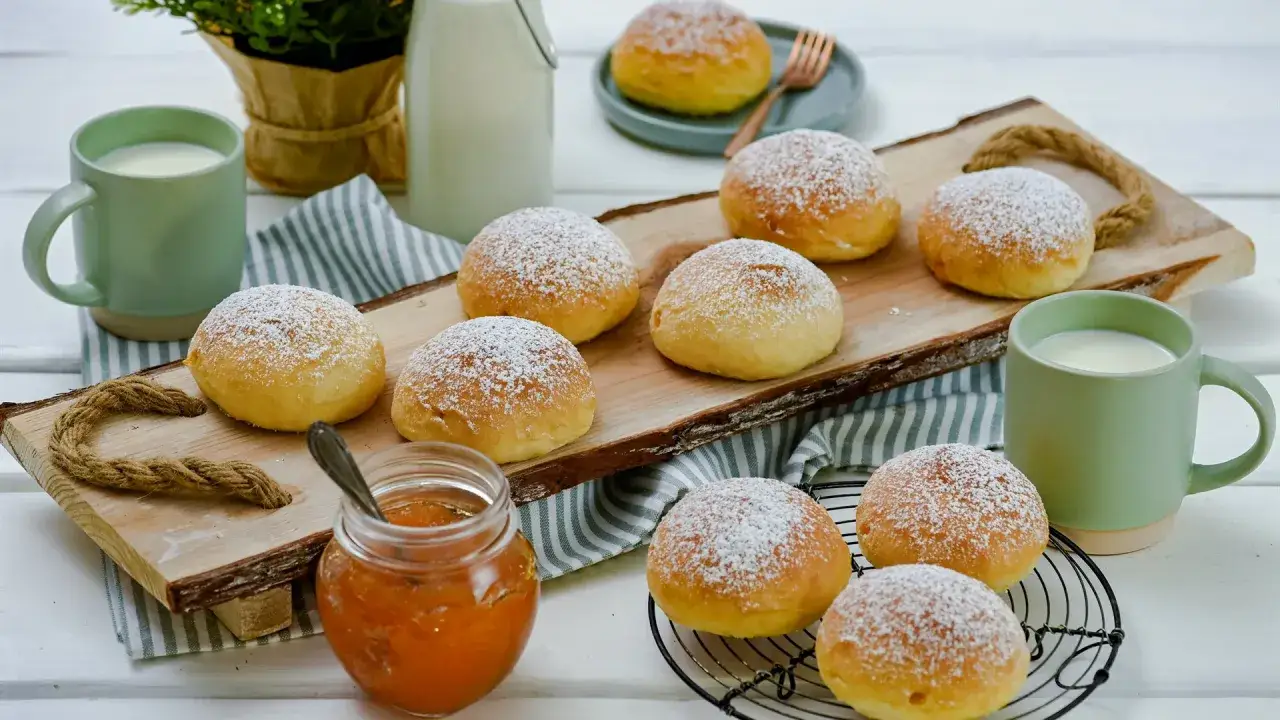 Lufterfrischte Krapfen im Airfryer, bestäubt mit Puderzucker, serviert mit Marmelade und Milch.