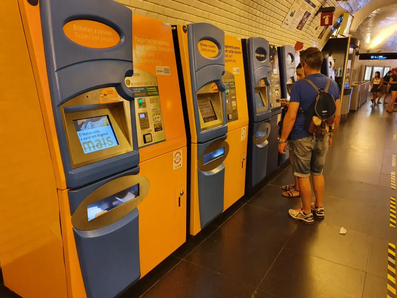 Fahrkartenautomaten in einer U-Bahn-Station. Ein Paar steht vor einem Automaten, um eine Fahrt mit dem viva viagem card zu kaufen.