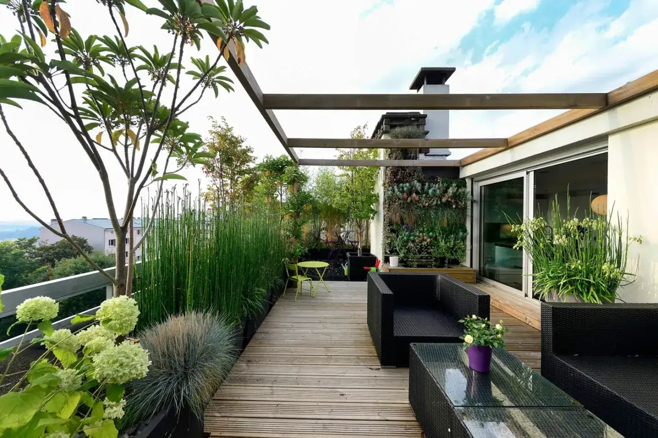 Terrazza moderna con arredi in vimini, giardino verticale e piante esotiche. Esempi progettazione giardini per spazi urbani.
