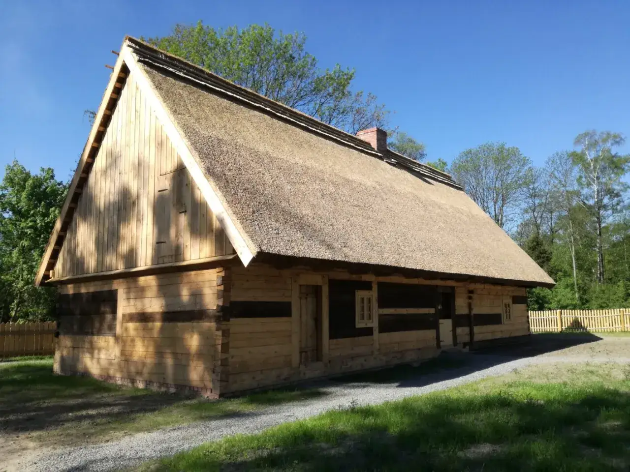 Drewniany dom z krytym strzechą dachem, część Muzeum Wsi Opolskiej.
