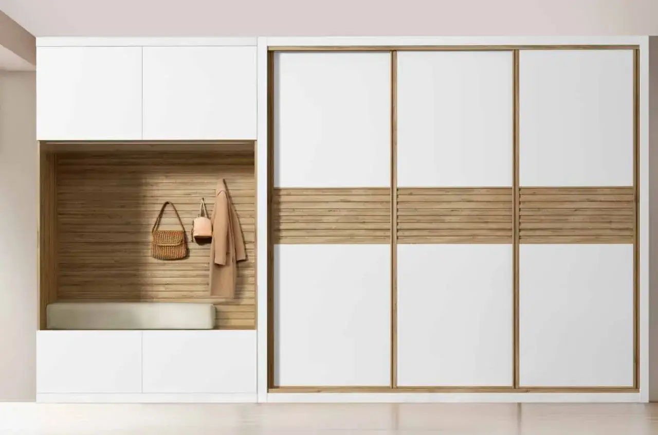 Armario empotrado moderno con puertas correderas blancas y detalles de madera. Incluye un banco y percheros para forrar armario empotrado.