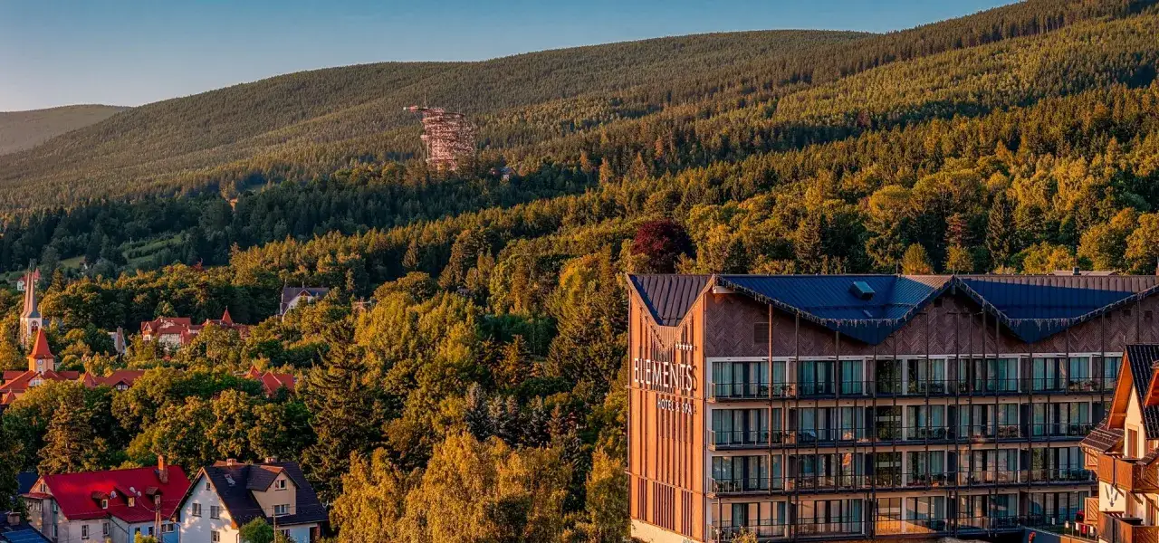 Hotel Elements w otoczeniu lasów, idealne miejsce na ferie dolnośląskie 2026. Widoczna wieża widokowa na wzgórzu.