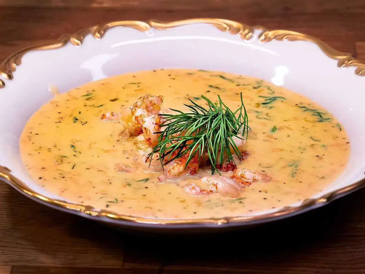 Krämig soppa med räkor och dill i en elegant skål. En härlig soppa med grädde som värmer.