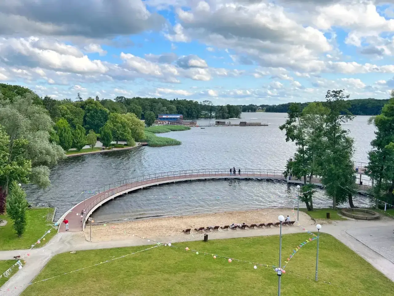 Malowniczy widok na jezioro z łukowatym mostkiem i plażą. Idealne miejsce na wypoczynek, odkryj szczecinek atrakcje!