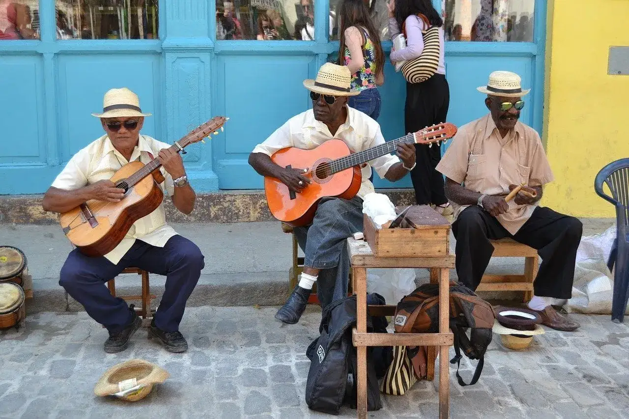 Tre musicisti suonano chitarre e percussioni, creando un'atmosfera perfetta per una salsa ballo latino.