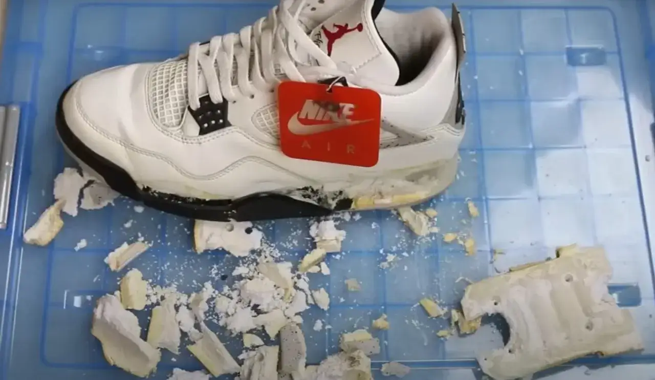Baskets blanches Air Jordan 4, la semelle qui se désagrège laisse des débris partout.
