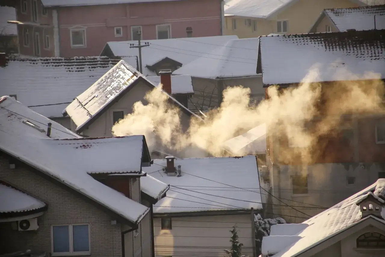 Zimowy krajobraz z dymem unoszącym się z komin&oacute;w. Smog co możemy zrobić? Zastan&oacute;wmy się nad czystym powietrzem.