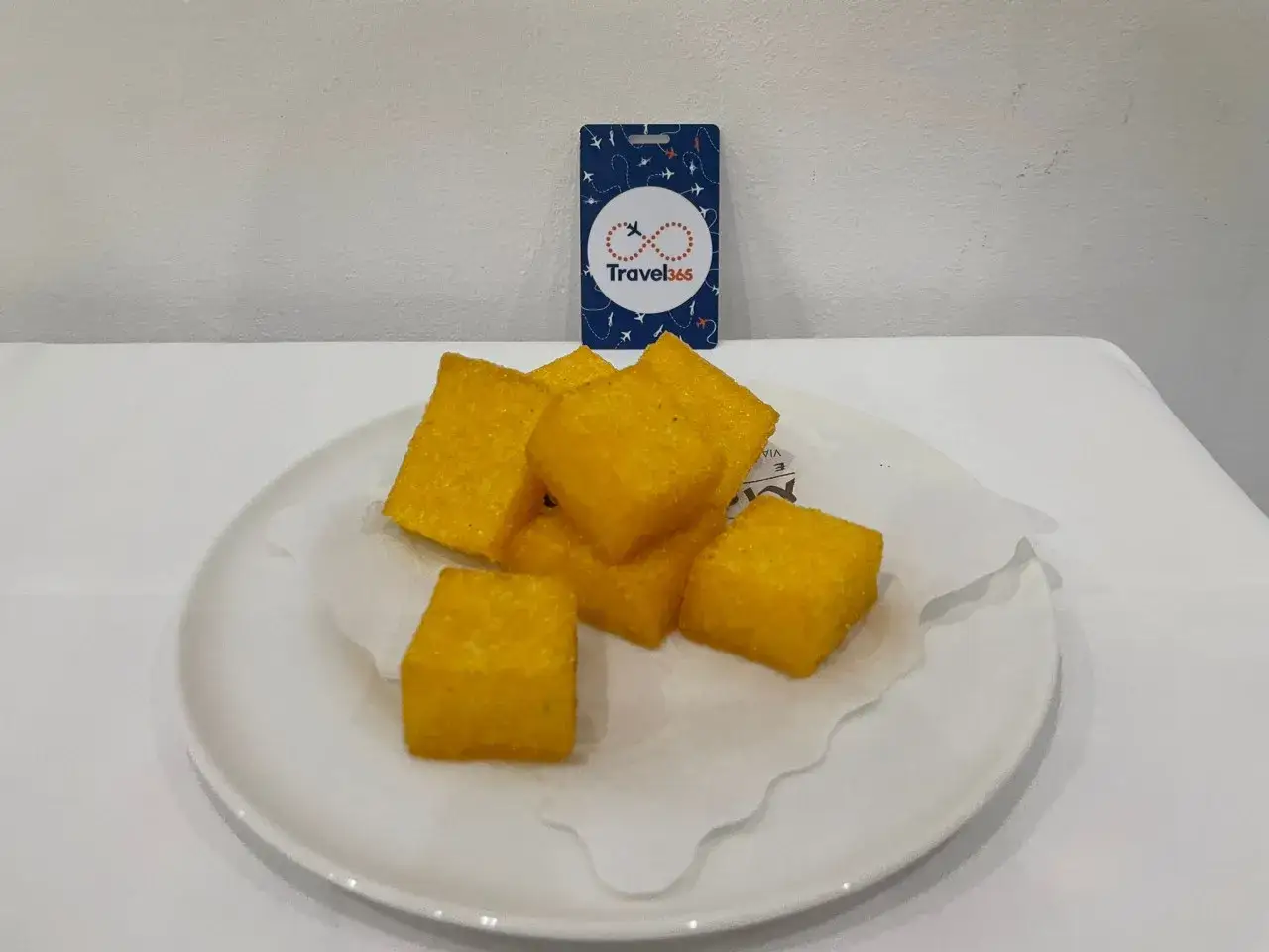 Frittelle di mais dorate, un assaggio della tipica cucina barese, servite su un piatto bianco.