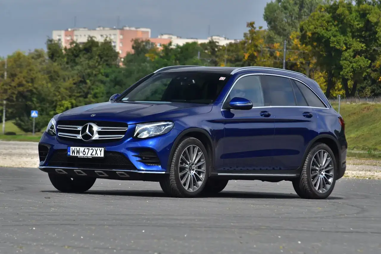 Niebieski Mercedes GLC na tle budynków i drzew. Sprawdź jego **mercedes glc wymiary** i możliwości.