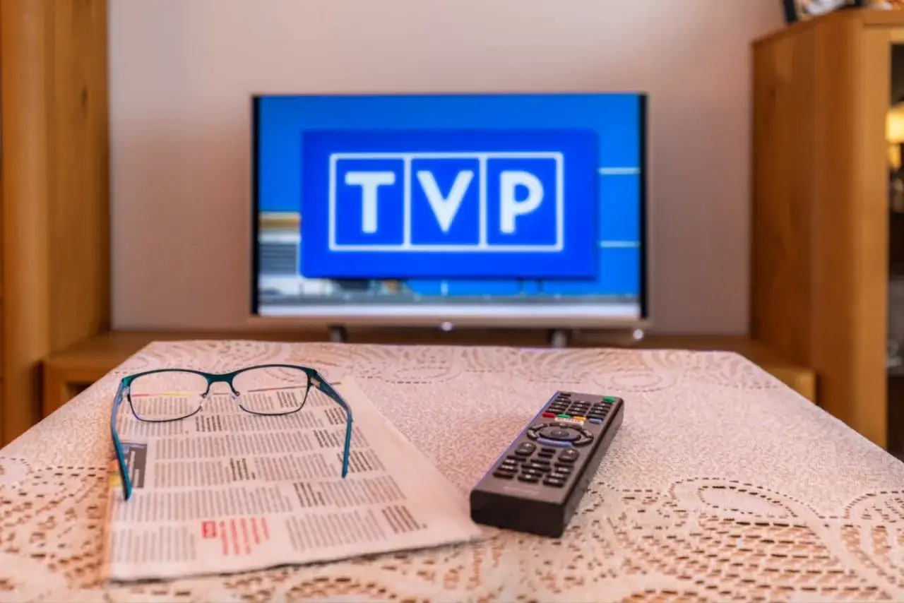 Okulary i pilot leżą na gazecie, a na ekranie telewizora widnieje logo TVP. Dziś brak sygnału telewizji naziemnej.