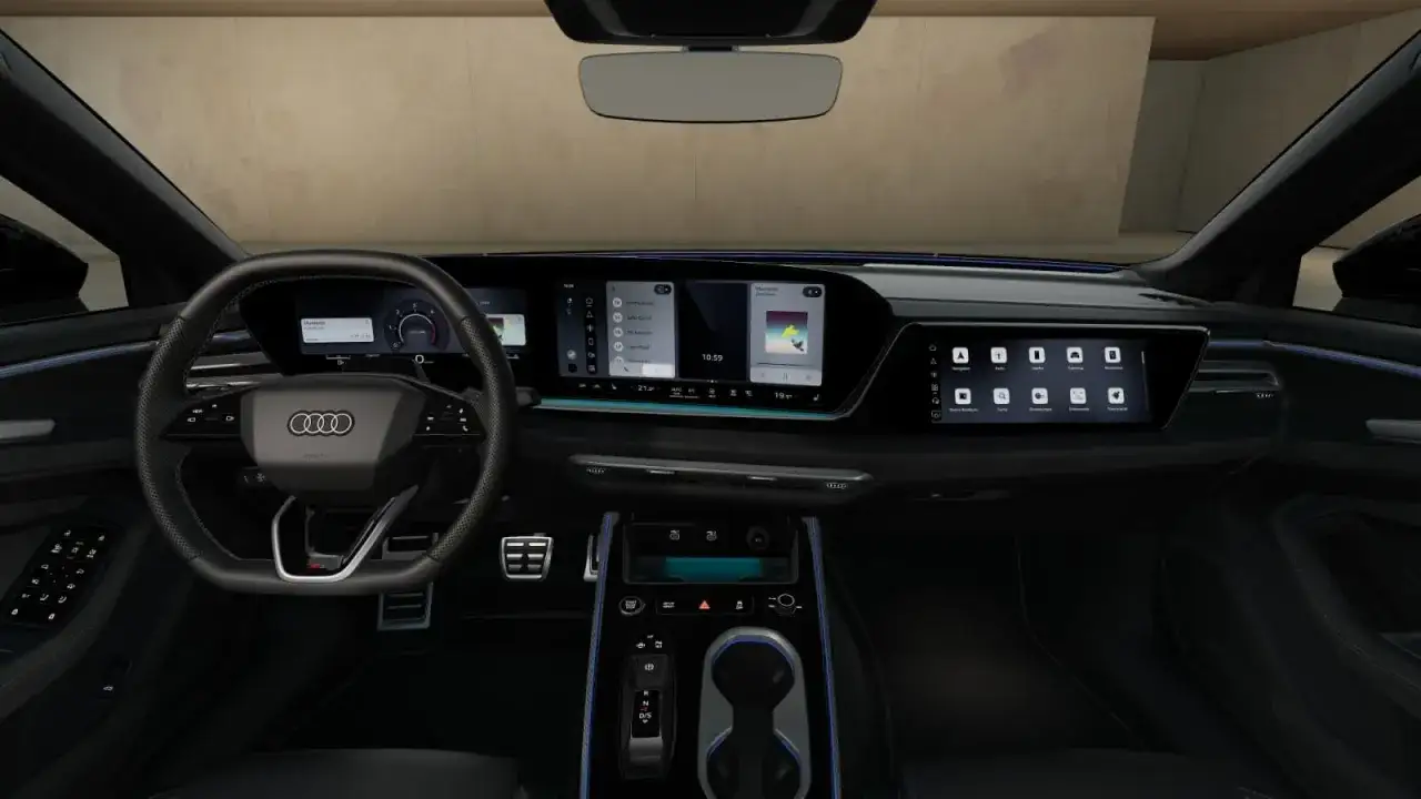 Wnętrze Audi A6 z cyfrowymi ekranami, kierownicą i konsolą środkową.
