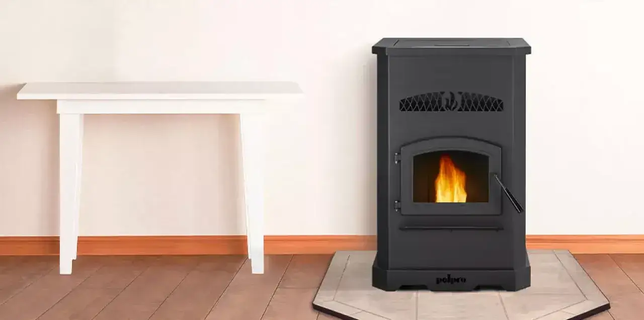 Estufa de pellets negra con fuego encendido, junto a una mesa blanca. No cae pellet en la estufa, garantizando limpieza.