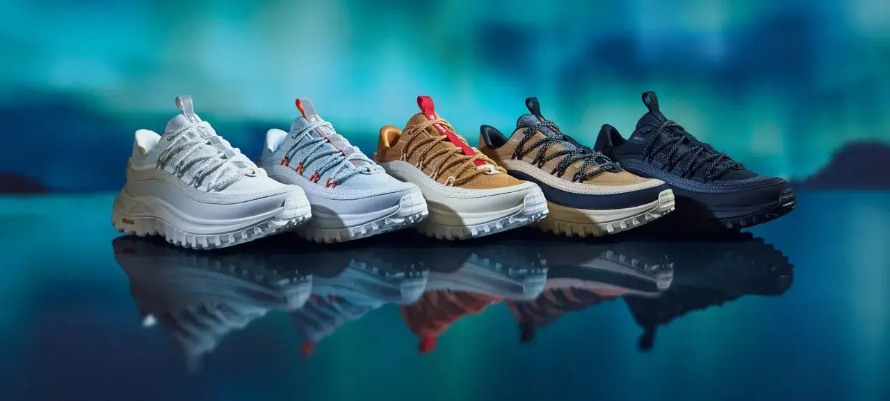 Cinque paia di scarpe in Gore-Tex da donna, in colori diversi, con lacci a vista e suole spesse, riflettono su una superficie lucida.