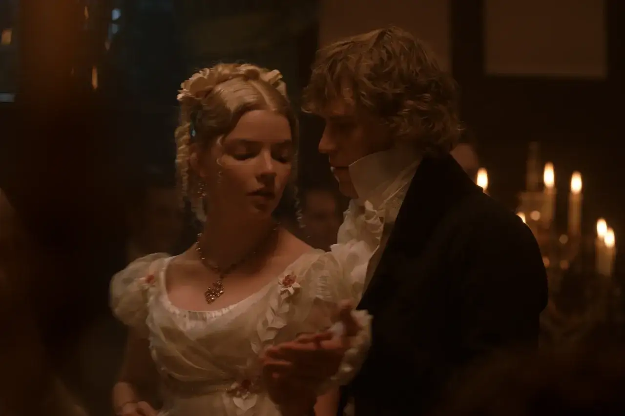 Emma i pan Knightley tańczą przy świecach. Urocza Emma w białej sukni i z kwiatami we włosach, obok elegancki pan Knightley.
