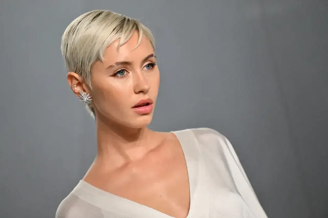 Krótka, blond fryzura wyszczuplająca twarz, podkreślona błyszczącymi kolczykami w kształcie gwiazdy.