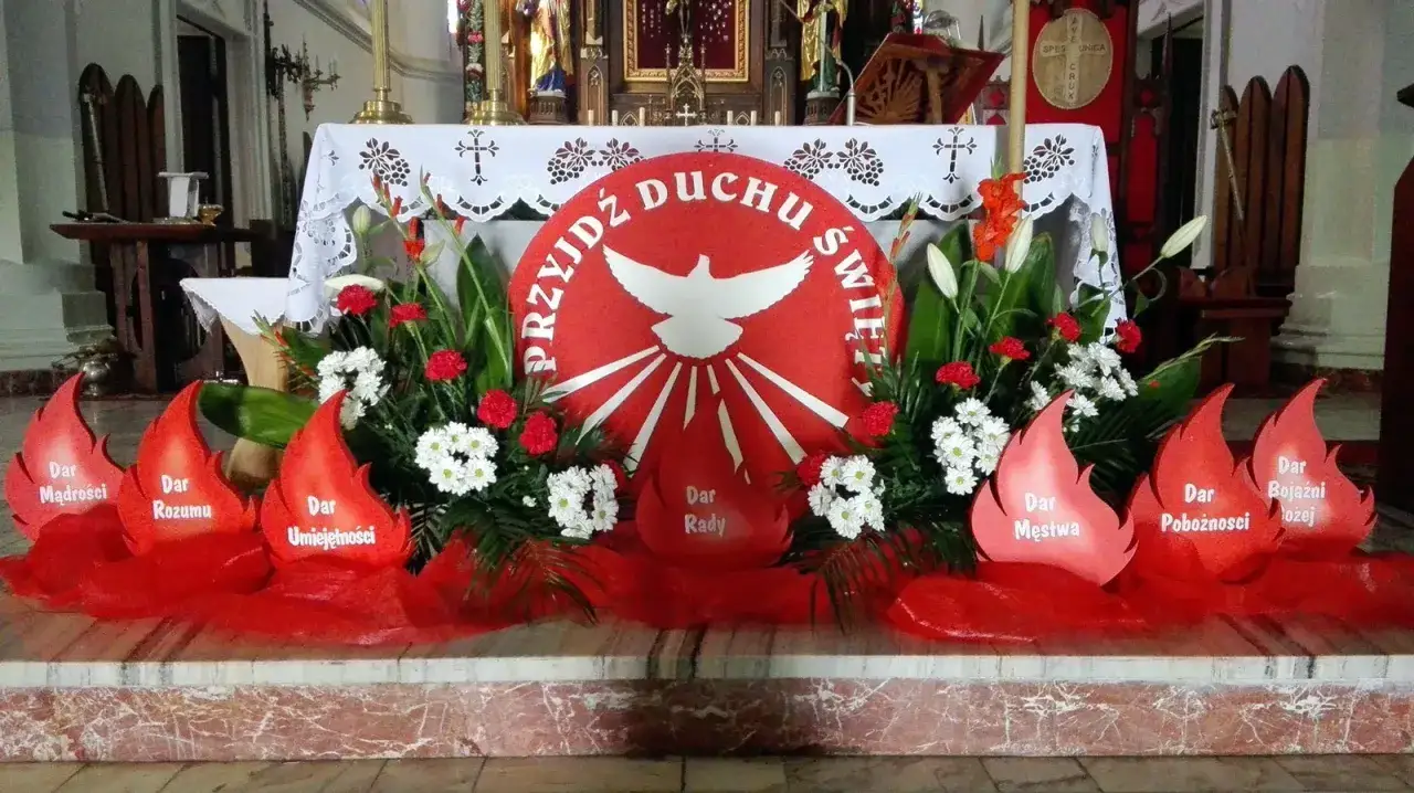 Ołtarz ozdobiony płomieniami symbolizującymi dary Ducha Świętego na bierzmowanie. Centralnie biały gołąb na czerwonym tle.