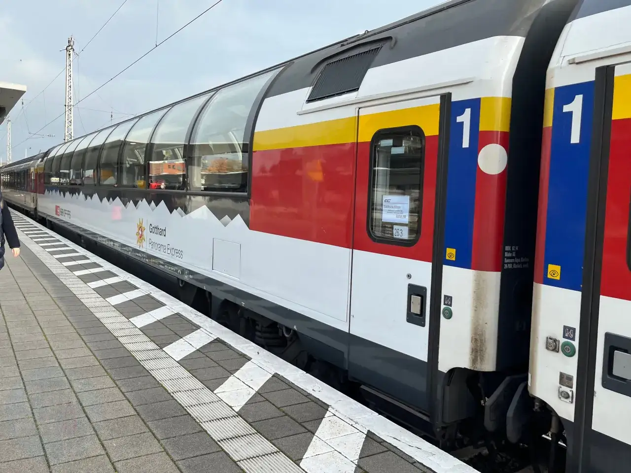 Der EC Gotthard Panorama Express mit Panoramawagen steht am Bahnsteig.