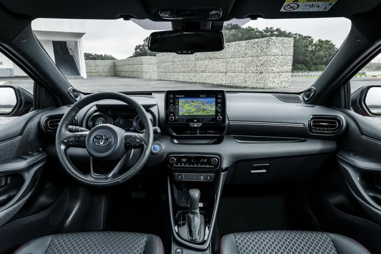 Interno della nuova Toyota Yaris GPL: volante, cruscotto digitale, schermo multimediale con navigatore e cambio automatico.