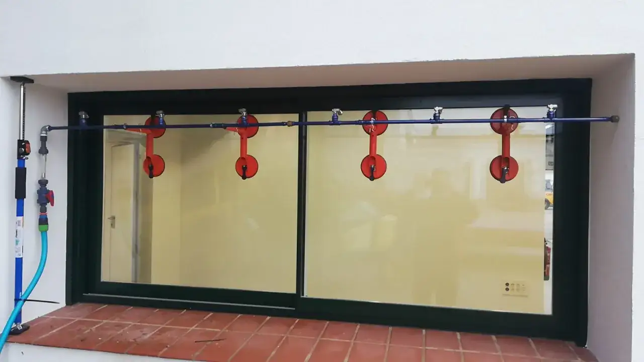 Sistema de ventosas rojas para probar la permeabilidad al aire clase 3 en una ventana corrediza.