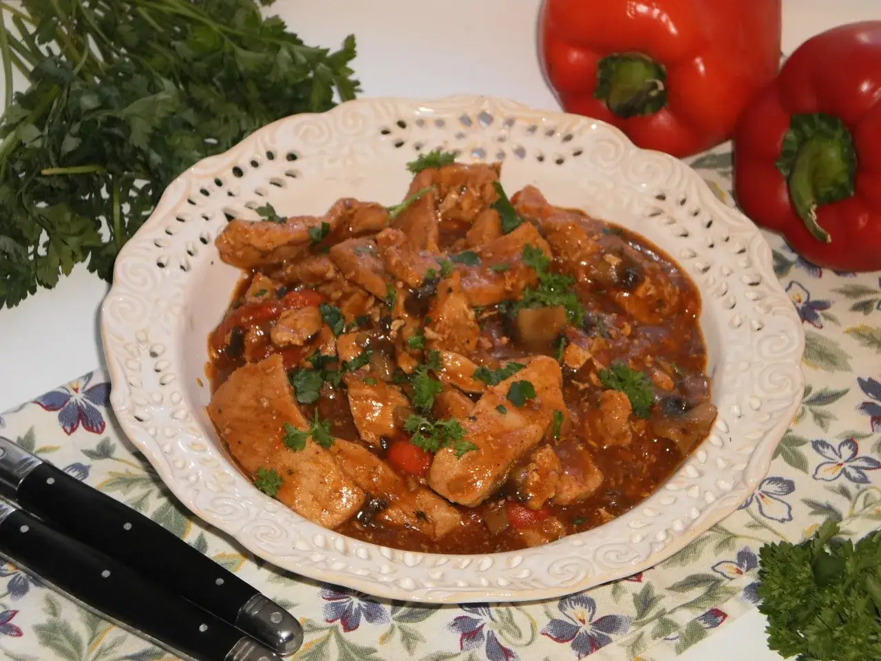 Schab po cygańsku z pieczarkami i papryką, aromatyczny gulasz w sosie, ozdobiony natką pietruszki.